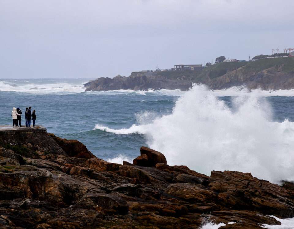 Varias personas se asoman al mar en el paseo de A Coruña. Foto: EFE
