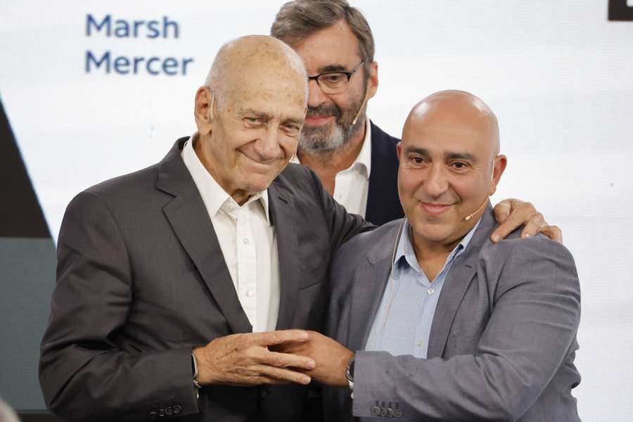 El ex Primer ministro Israel, Ehud Olmert (izq), y el político activista Palestino de Jerusalén, Samer Abdelrazzak Sinijlawi, (d) se abrazan tras su debate sobre la situación en Gaza en el Foro La Toja